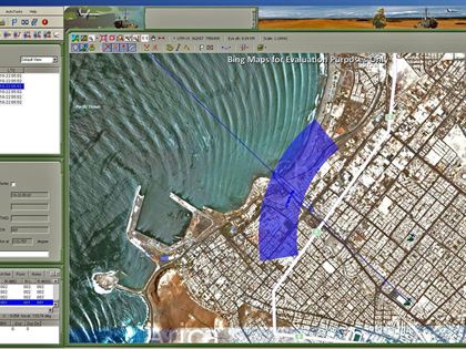 GenCOM UI++ showing a GSM sector beam and bearing lines converging on an emitter in a coastal city