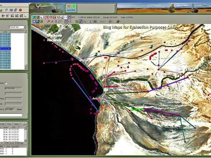 GenCOM UI++ showing a transmitter list, the selected emitter's parameters, and coloured inter-transmitter links plotted across mapped terrain